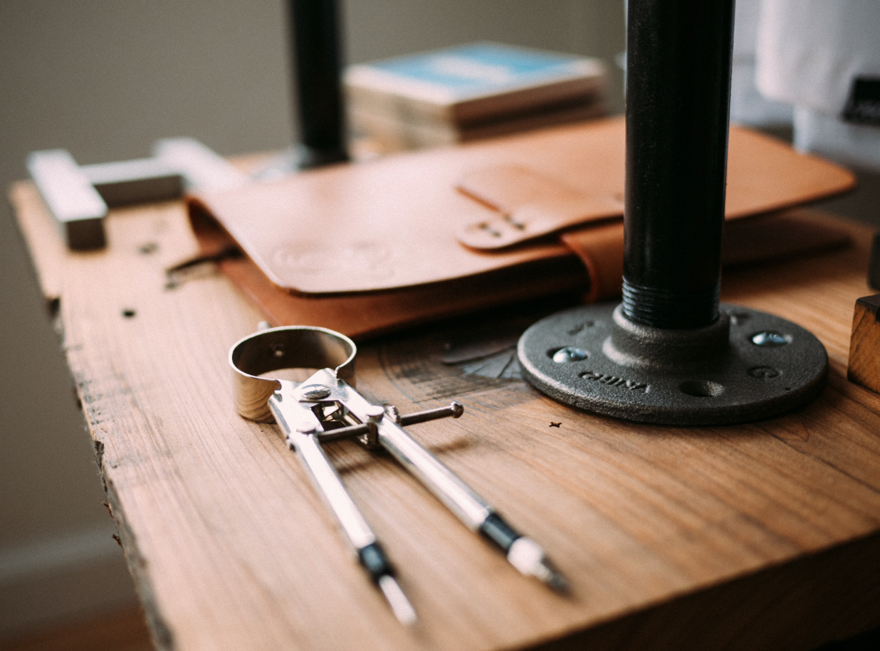 Woodworking station with compass and leather notebook.